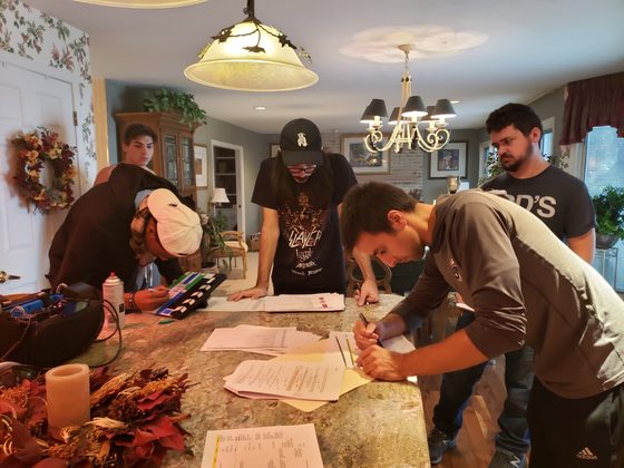 Crew bent over script pages and notes at the counter